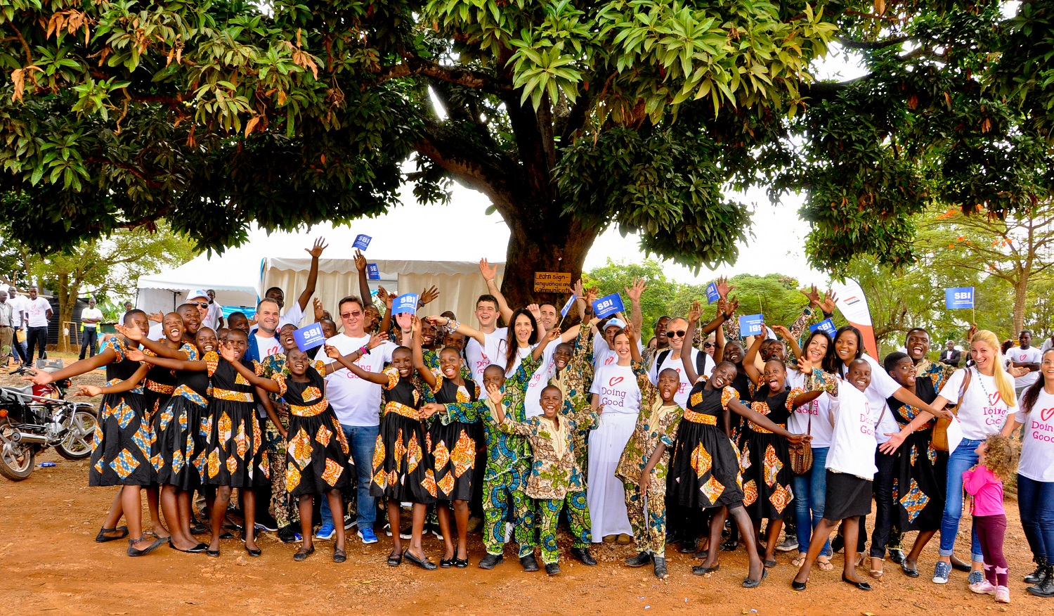 Volunteers and kids from Conord Roy Muasasko in Uganda smile with happiness.